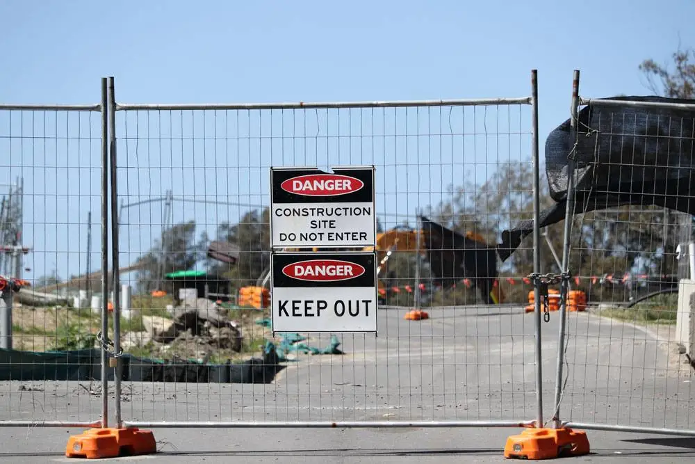 Construction site security fence with access restricted signage in Los Angeles — protected by Safety Host Unit