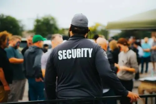 Security guard monitoring and protecting a crowd in Los Angeles, ensuring public safety and strong visible presence