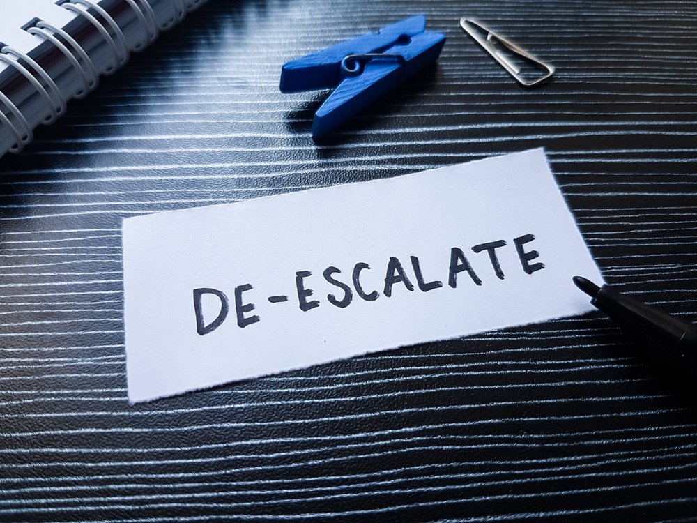 De, ,escalate,writting,on,table,background.