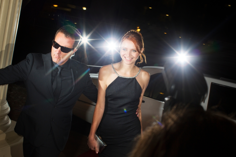 Bodyguard,escorting,smiling,celebrity,arriving,at,event